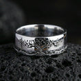 Load image into Gallery viewer, Polished silver Tree of Life engraved ring on volcanic rock, clean reflective finish highlighting the detailed canopy and root linework, premium close-up.
