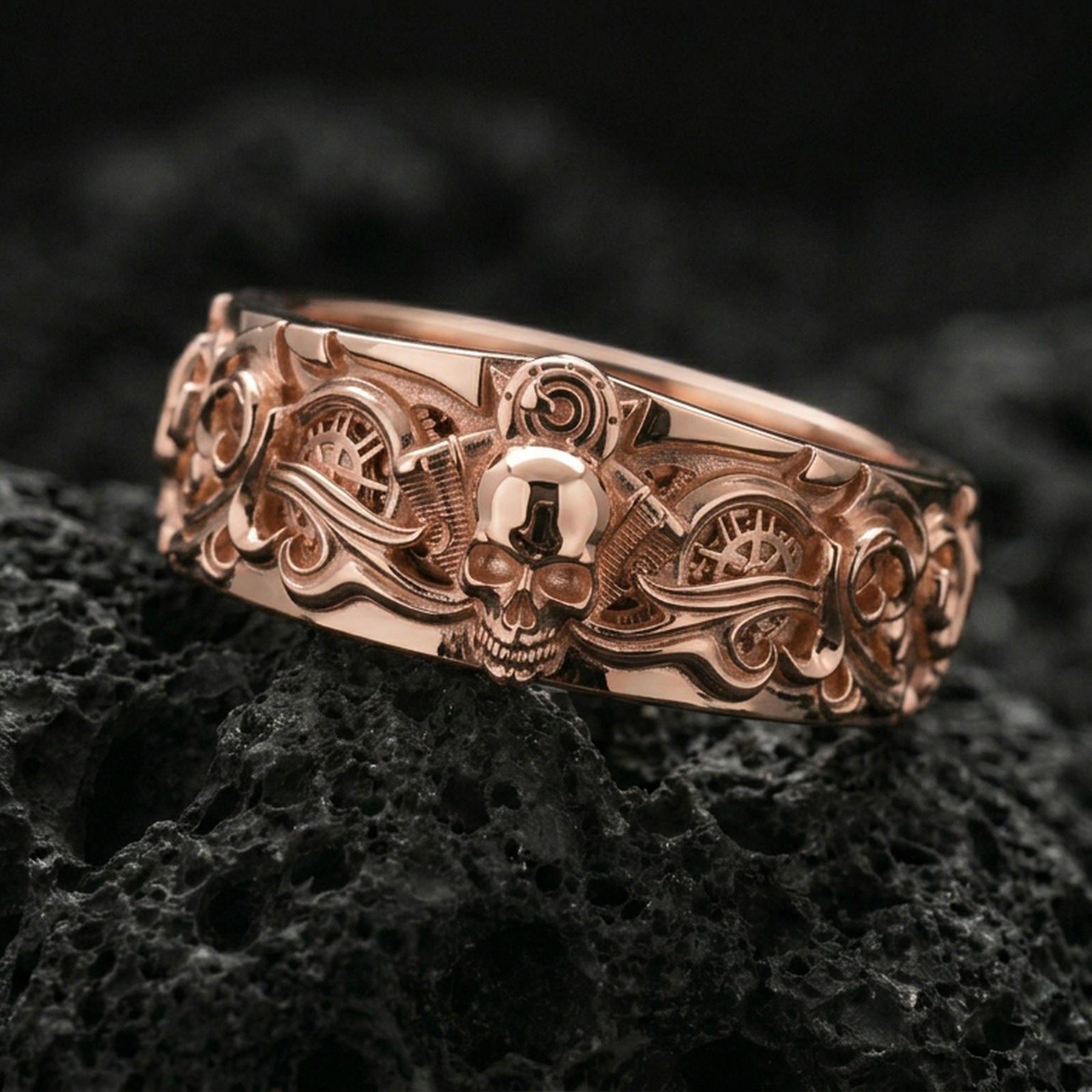 Rose gold plated gothic skull gear band ring on volcanic rock, soft warm highlights enhancing the skull centerpiece and ornate scrollwork, luxury product shot.