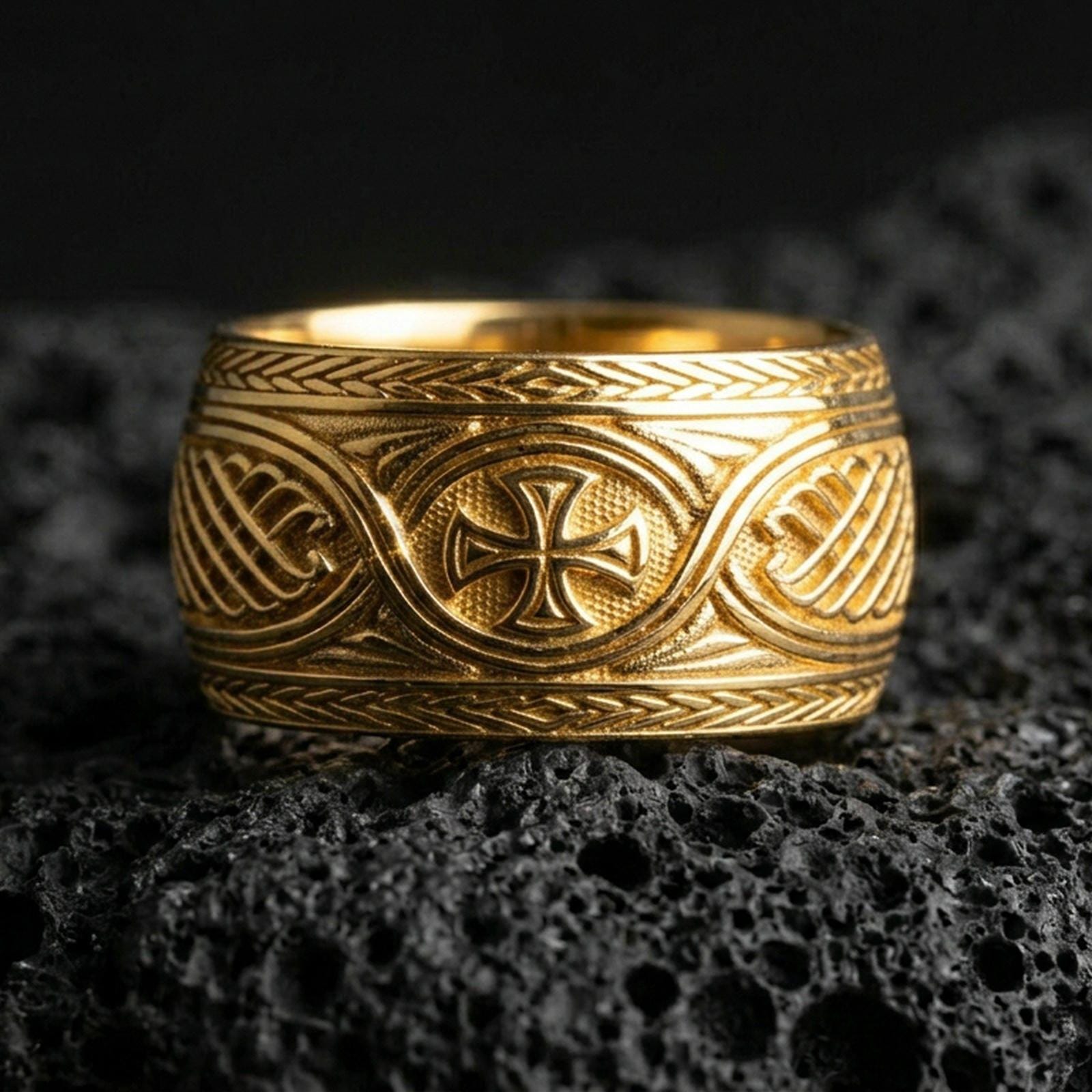 Gold plated Celtic knot and iron cross ring on black volcanic stone, warm reflective finish emphasizing the braided borders and central cross.