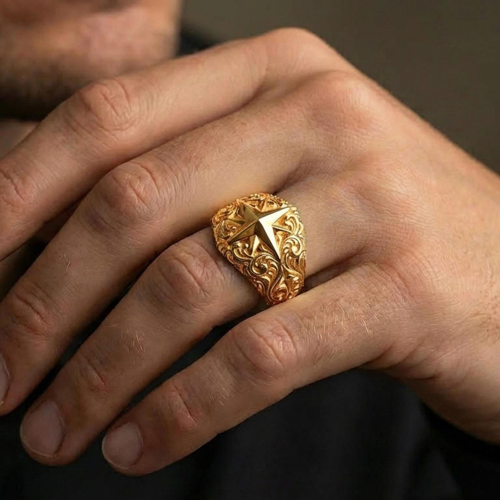 Gold plated North Star statement ring worn on finger, rich warm shine defining the compass star edges and sculpted ornamental band.