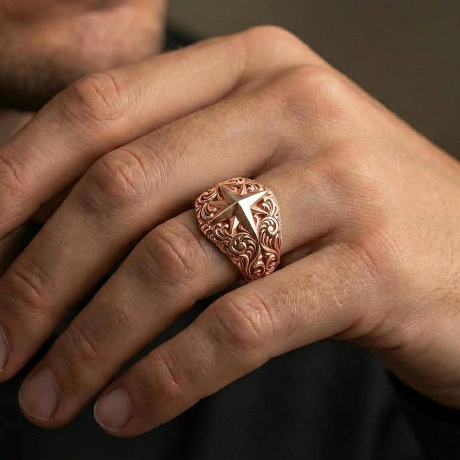 Rose gold plated North Star compass ring worn on finger, refined warm glow with crisp star points and elegant engraved scroll detailing.