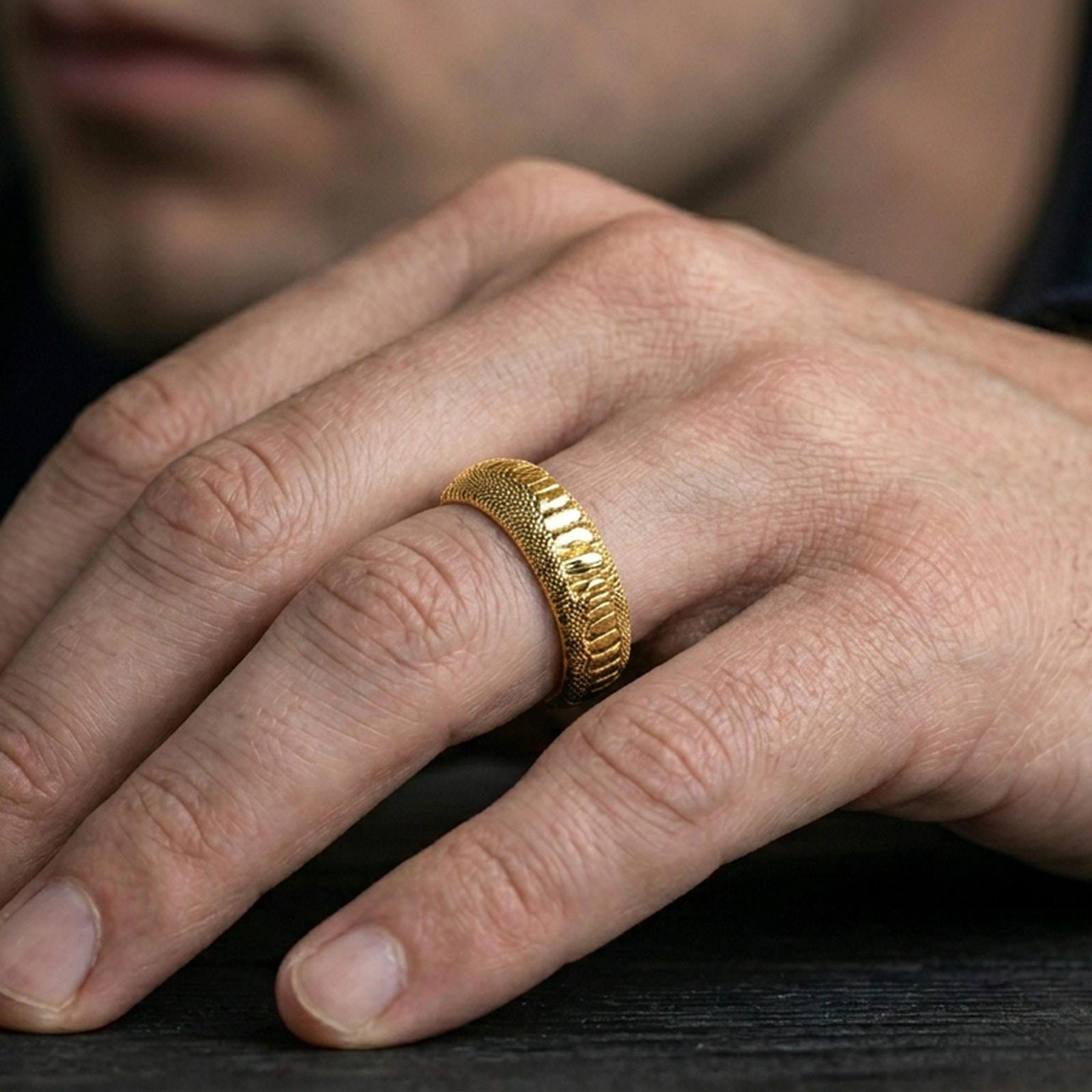 Gold plated serpent skin wedding band worn on finger, rich warm shine defining each raised scale and premium comfort fit.