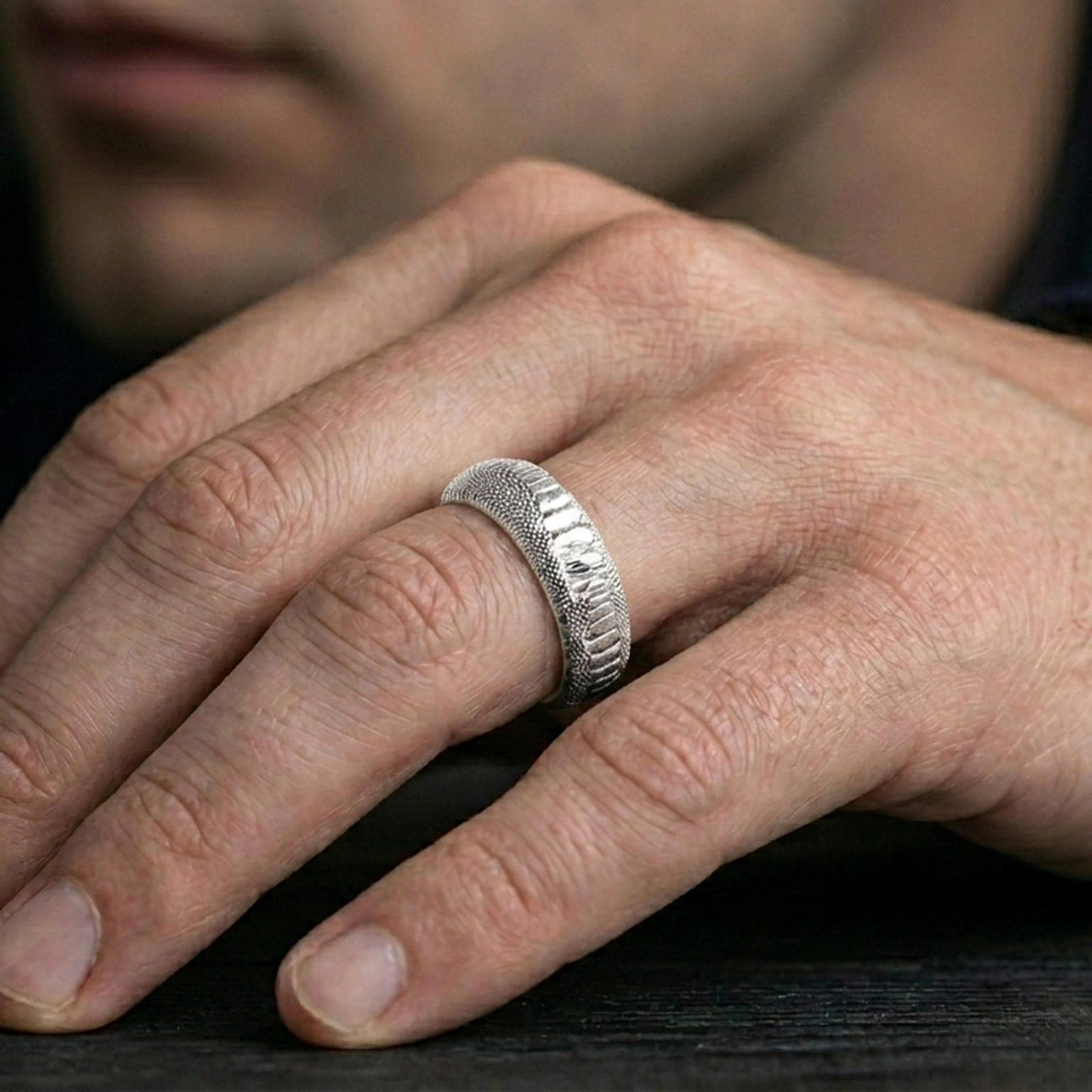 Polished silver snake scale ring worn on finger, clean modern sheen with detailed reptile texture and smooth rounded profile.