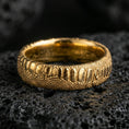 Load image into Gallery viewer, Gold plated serpent skin ring on black volcanic stone, warm reflective finish emphasizing the raised scale texture and carved depth.
