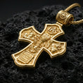 Load image into Gallery viewer, Holy Trinity cross pendant on volcanic stone showing a bright gold plated look that emphasizes the raised icons and borders.
