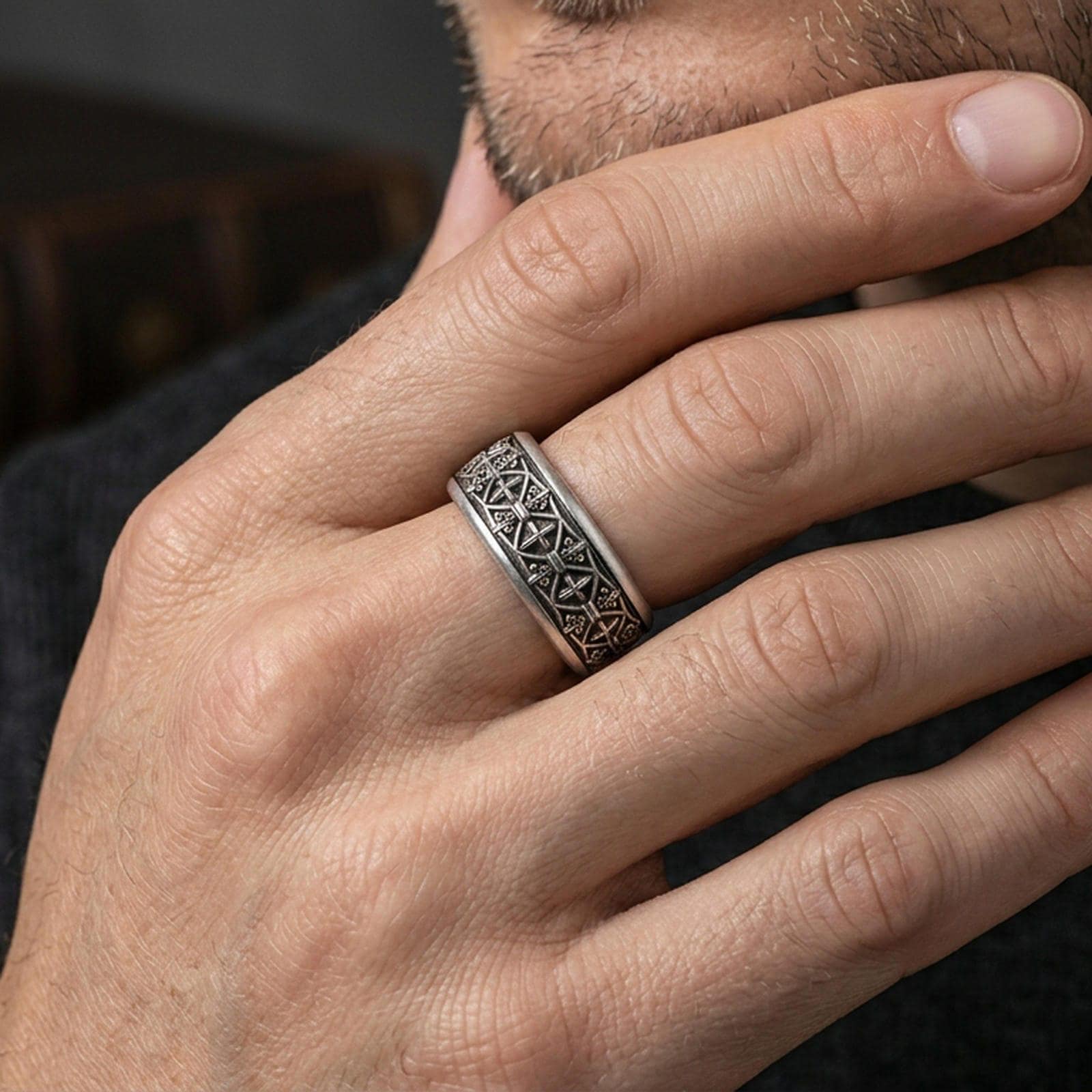 Oxidized sterling silver fleur de lis ring worn on a finger, showcasing the detailed medieval pattern around the band.
