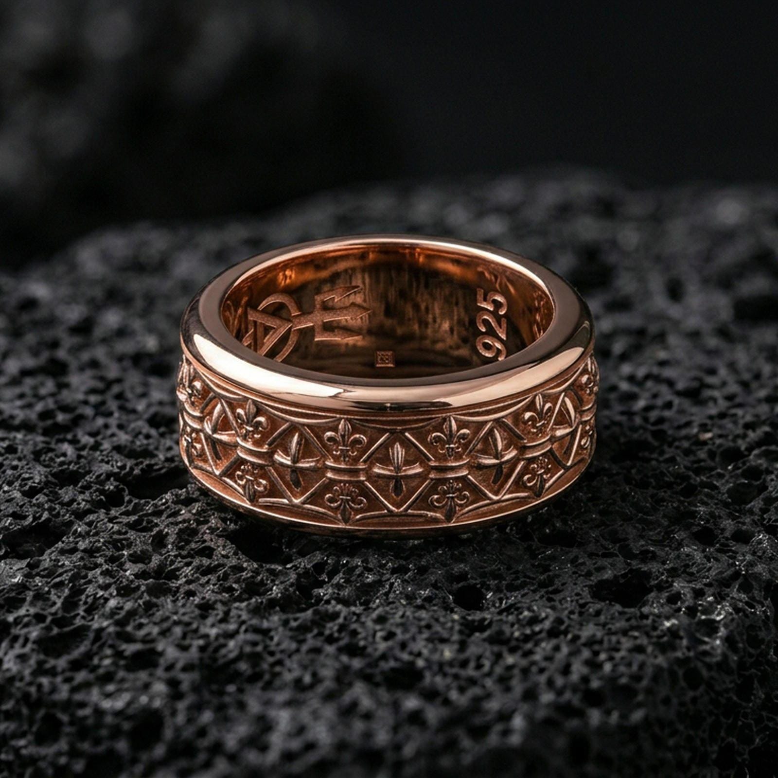 Fleur de lis band ring on volcanic stone with a rose gold plated look, showing the repeating motifs and smooth comfort-fit edges.