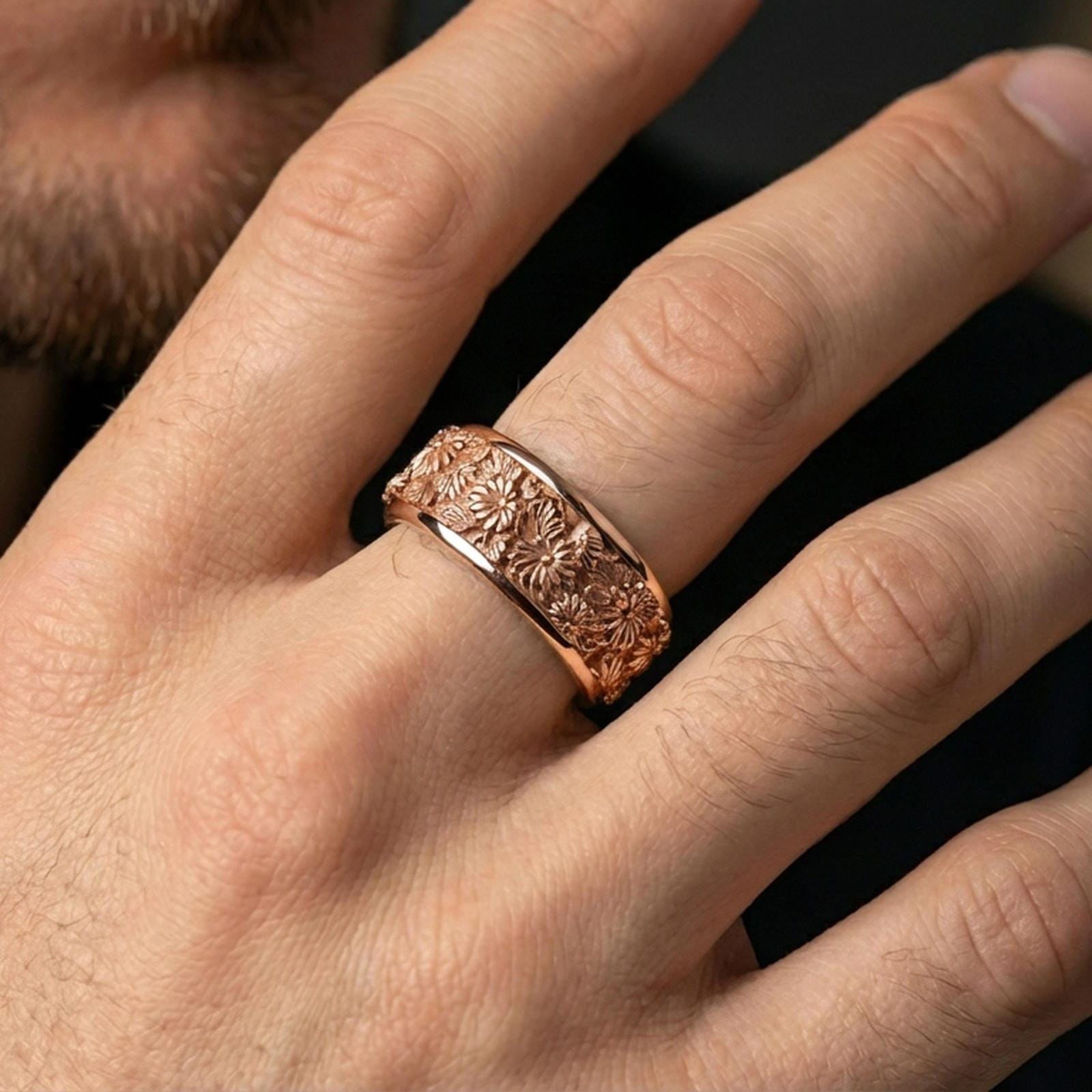 Rose gold plated floral spinner ring on a finger, elegant metallic glow with daisy engravings and a comfort-fit style.