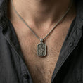 Load image into Gallery viewer, Saint Michael dog tag pendant worn on the neck, showing scale and how the rectangular tag lays flat on the chest.
