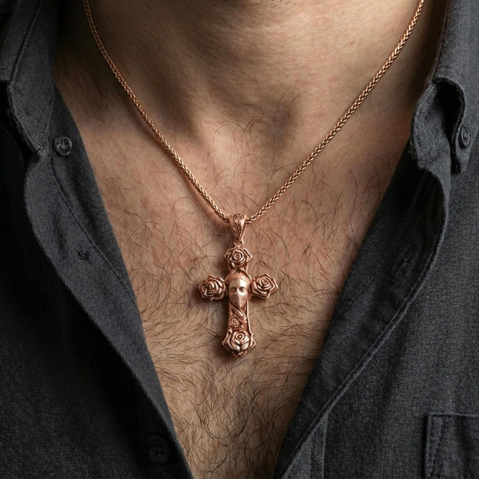 Rose gold plated rose cross pendant with central masked face worn on the neck in a detailed lifestyle composition with a masculine styling angle