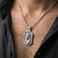 Load image into Gallery viewer, Polished silver Christian Jesus pendant with INRI inscription worn on the neck in a close lifestyle frame, highlighting the detailed portrait and spiritual symbolism
