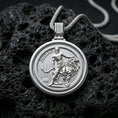 Load image into Gallery viewer, Polished silver Lion of Judah pendant with a round spinner-style frame, detailed lion relief, and sunrise motif placed on textured volcanic rock in a premium studio product shot
