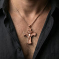 Load image into Gallery viewer, Rose gold plated religious Jesus cross pendant with detailed portrait relief worn on the neck in a refined lifestyle shot with a warm and elegant presentation
