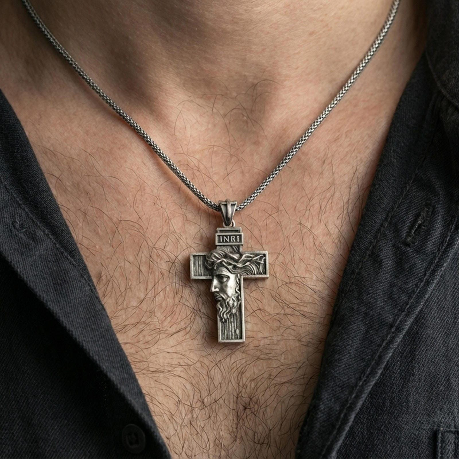 Oxidized Jesus cross pendant with crown of thorns worn on the neck in a lifestyle jewelry shot, styled against the chest for a bold and devotional look