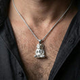 Load image into Gallery viewer, Sterling silver Egyptian god Khnum necklace on the neck, macro lifestyle image highlighting the polished silver finish and detailed seated deity relief
