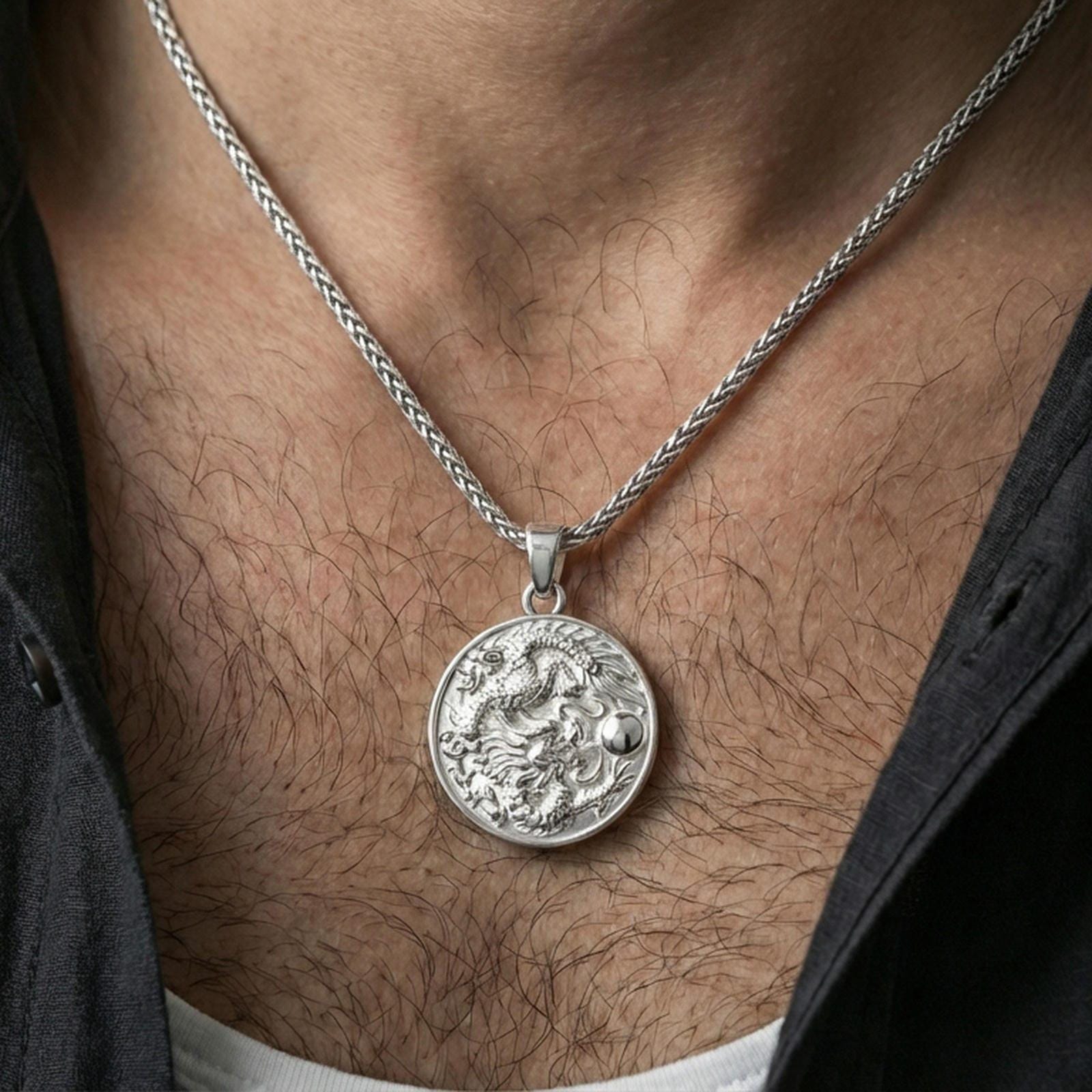 Sterling silver circular dragon pendant necklace on the neck, macro lifestyle image showing the polished silver finish and detailed scale texture