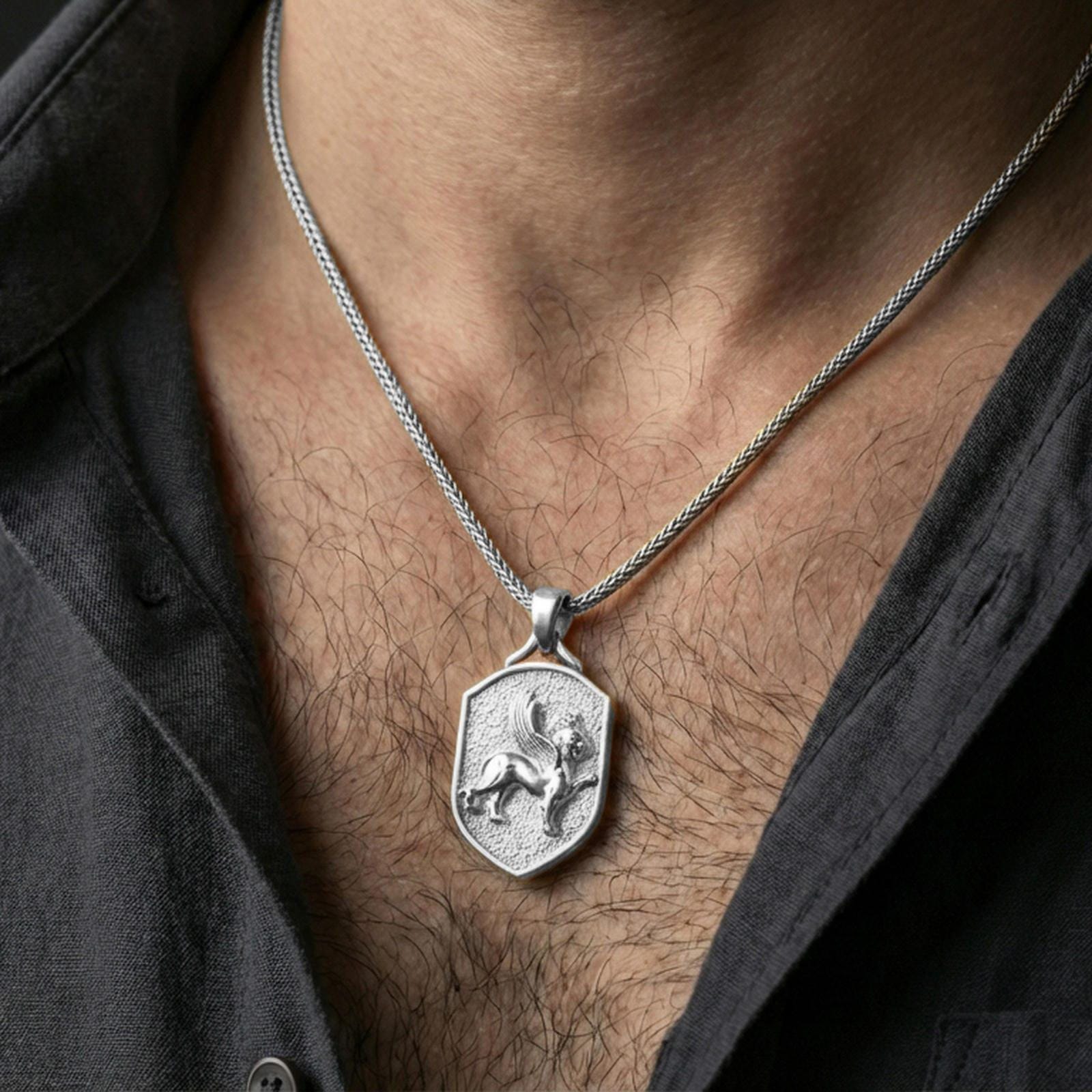 Sterling silver winged lion crest pendant necklace on the neck, macro lifestyle image showing the polished silver finish and shield silhouette