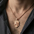 Load image into Gallery viewer, Sterling silver winged lion crest pendant necklace on the neck, macro lifestyle shot showcasing the rose gold plated finish and textured shield background
