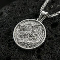Load image into Gallery viewer, Polished silver round dragon coin pendant necklace on textured volcanic rock, crisp macro product photo emphasizing clean edges and sharp relief detailing.
