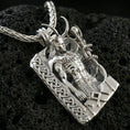 Load image into Gallery viewer, Polished silver Loki pendant necklace on textured volcanic rock, sharp macro product photo emphasizing the clean sculpted muscles, rune accents, and crisp edges.
