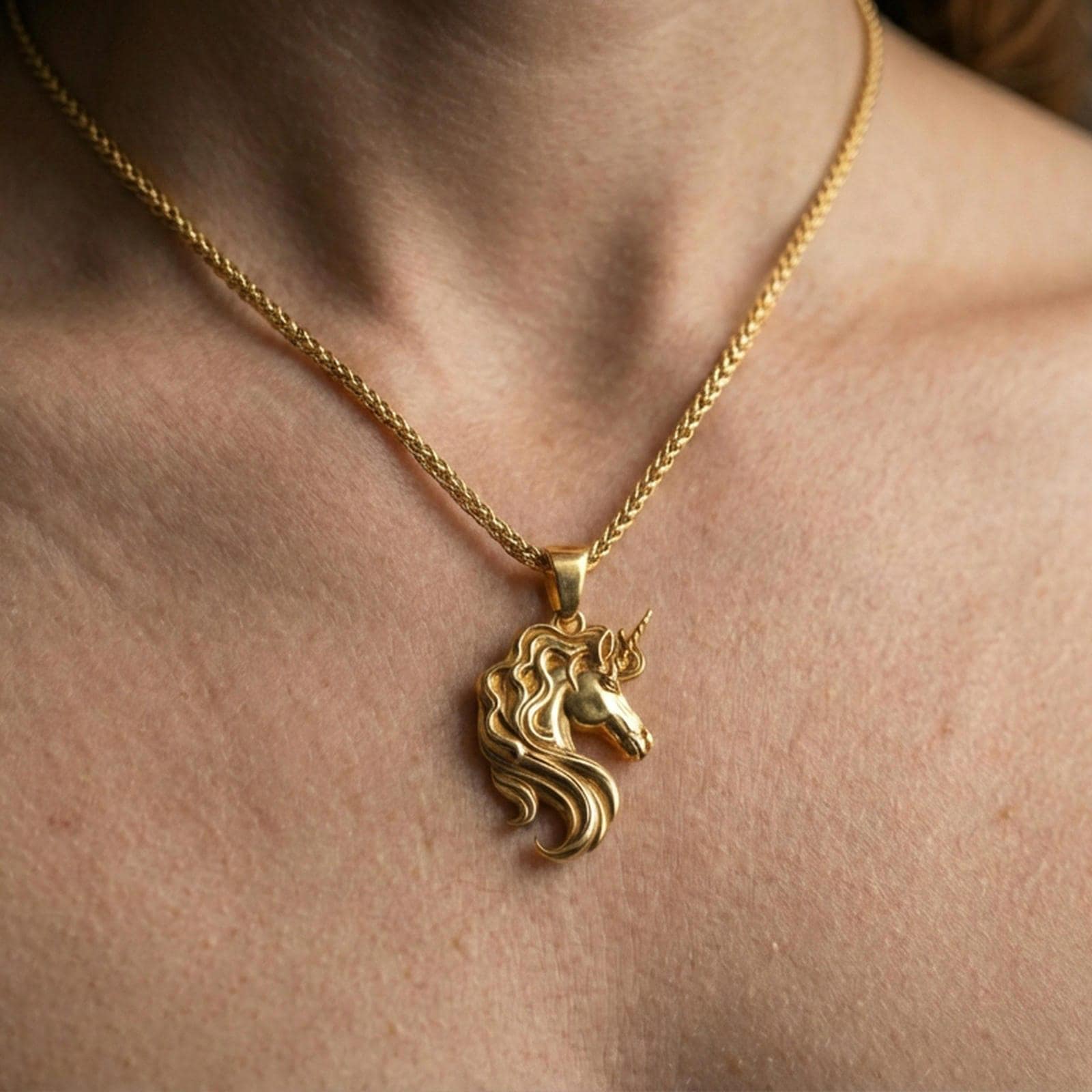 Gold plated unicorn head pendant necklace worn on the neck, lifestyle photo featuring warm tone finish and bold statement charm presence.