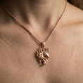 Load image into Gallery viewer, Rose gold plated unicorn head pendant necklace worn on the neck, lifestyle wear shot with elegant rosy shine and clear horn-and-mane sculpting.
