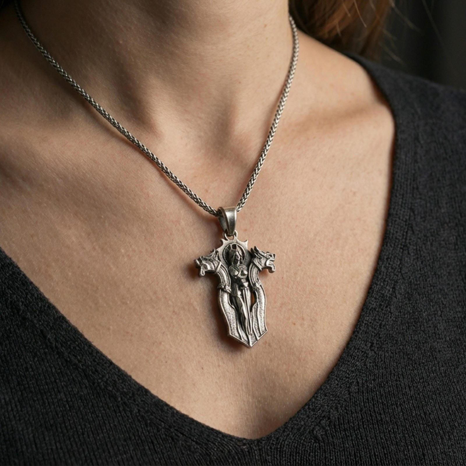 Oxidized gothic cross pendant necklace worn on the neck, lifestyle framing showing realistic scale and bold darkened vintage texture against the chest.