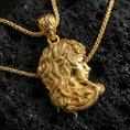Load image into Gallery viewer, Gold plated Medusa profile pendant necklace on textured volcanic rock, premium close-up with warm reflective shine across the gorgon face and high-relief snake crown.
