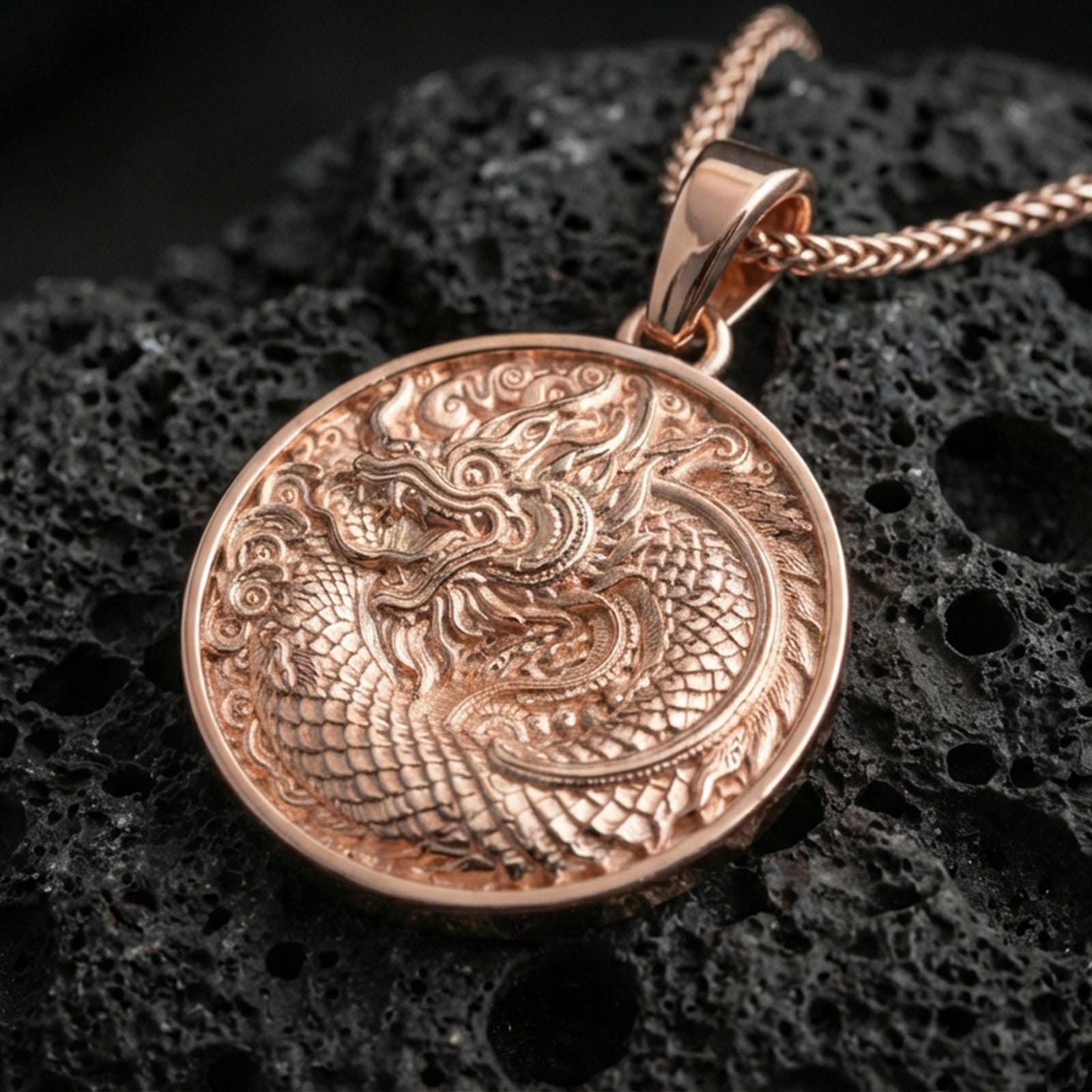 Rose gold plated oriental dragon medallion pendant necklace on textured volcanic rock, centered studio-style close-up showcasing soft rosy glow and intricate coiling dragon engraving.