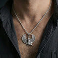 Load image into Gallery viewer, Polished silver winged goddess Isis pendant necklace worn on the neck, clean lifestyle wear shot capturing bright shine and the detailed feather relief in natural light.
