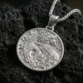 Load image into Gallery viewer, Polished silver dragon medallion pendant necklace on textured volcanic rock, crisp macro product photo emphasizing sharp scale texture, clean edges, and detailed engraved relief.
