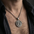 Load image into Gallery viewer, Oxidized dragon medallion pendant necklace worn on the neck, lifestyle framing showing realistic scale and bold vintage contrast against the chest.

