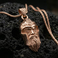 Load image into Gallery viewer, Rose gold plated Odin pendant necklace on textured volcanic rock, centered studio-style close-up showcasing soft rosy glow and intricate Norse detailing on the helmet and beard.
