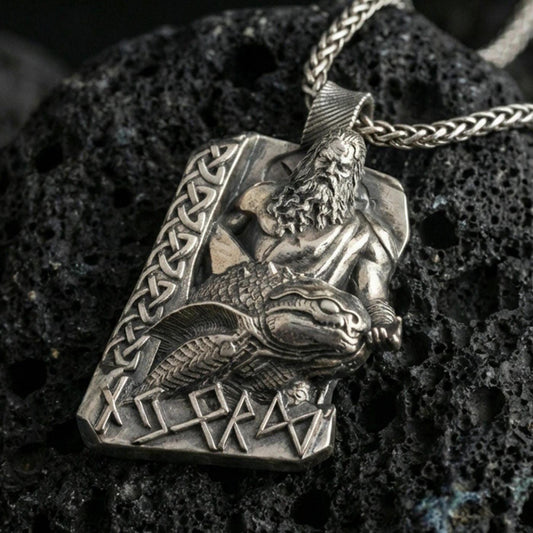 Oxidized Njord Norse sea god pendant necklace on textured volcanic rock, centered close-up highlighting the bearded deity relief, sea-creature motif, rune lettering, and deep antique contrast.
