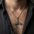 Load image into Gallery viewer, Oxidized winged goddess ankh pendant necklace worn on the neck, lifestyle framing showing realistic scale and bold vintage contrast against the chest.
