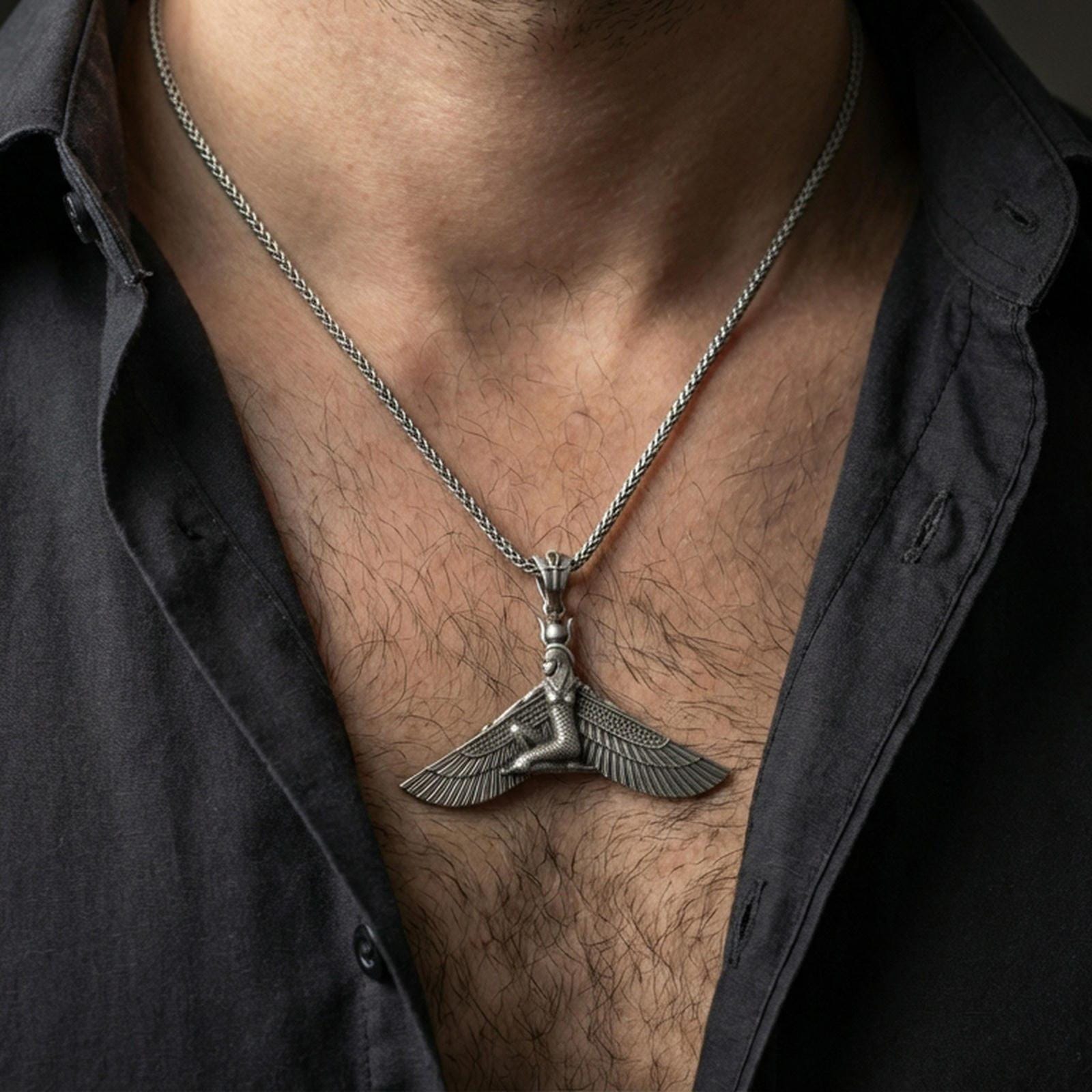 Oxidized winged goddess ankh pendant necklace worn on the neck, lifestyle framing showing realistic scale and bold vintage contrast against the chest.