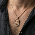 Load image into Gallery viewer, Rose gold plated Catholic Saint Francis pendant worn on the neck in a refined lifestyle shot with a warm and elegant presentation
