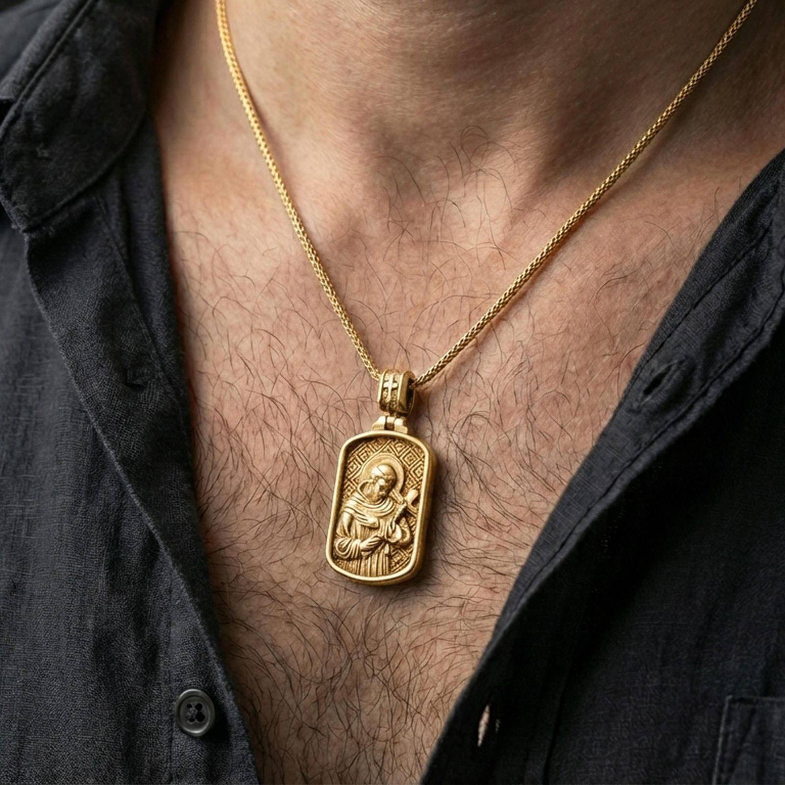 Gold plated Saint Francis necklace worn on the neck in a premium lifestyle composition with classic Christian jewelry styling