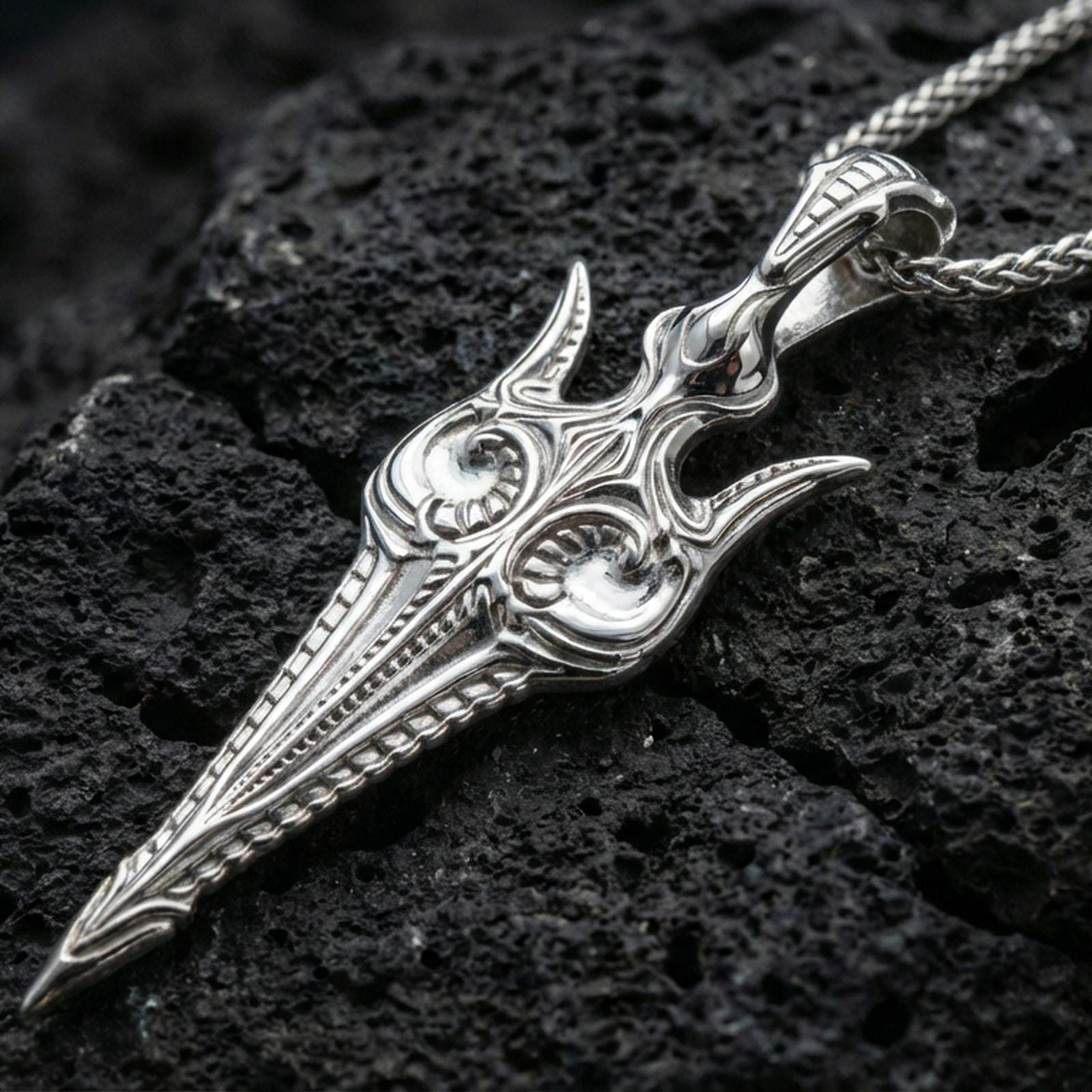 Polished silver Gungnir spear pendant necklace on textured volcanic rock, crisp macro product photo emphasizing clean edges, precise engraving, and bright reflective highlights along the blade.