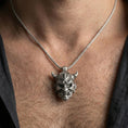 Load image into Gallery viewer, Oxidized oni mask pendant necklace worn on the neck, lifestyle framing showing realistic scale and bold vintage contrast against the chest.
