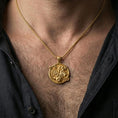Load image into Gallery viewer, Gold plated Saint George necklace with circular warrior design and Corinthians inscription worn on the neck in a premium lifestyle composition with classic devotional jewelry styling
