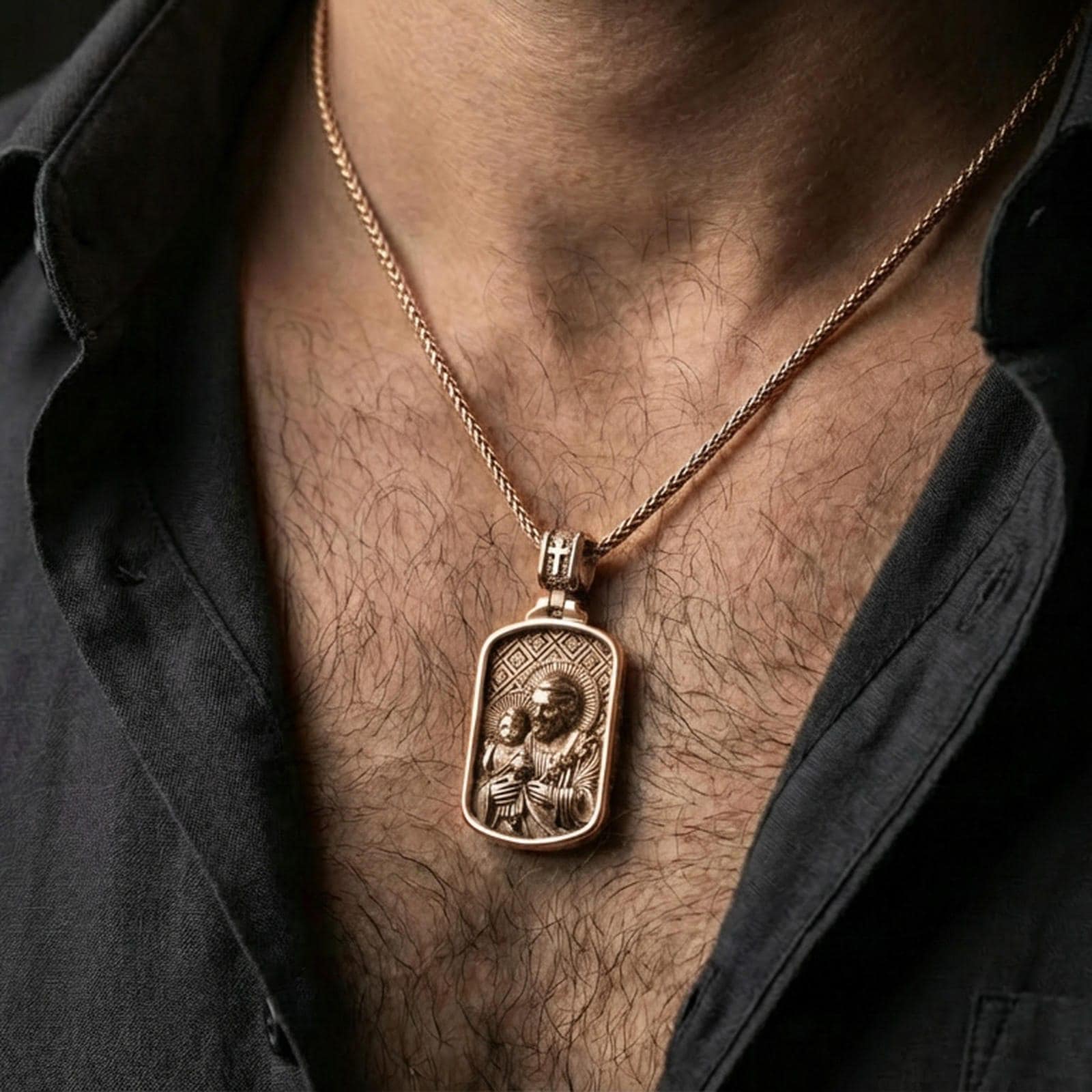 Rose gold plated Catholic Saint Joseph pendant with Child Jesus worn on the neck in a refined lifestyle shot with a warm and elegant presentation