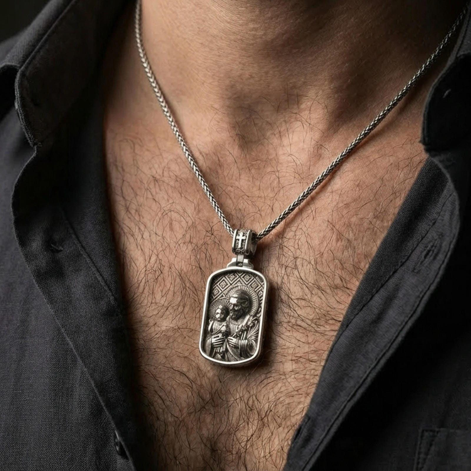 Oxidized Saint Joseph pendant with Child Jesus worn on the neck in a lifestyle jewelry shot, styled against the chest for a devotional and timeless look