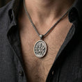 Load image into Gallery viewer, Oxidized saint medallion pendant with lion and scripture motif worn on the neck in a lifestyle jewelry shot, styled against the chest for a devotional and timeless look
