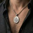 Load image into Gallery viewer, Polished silver religious saint pendant with seated figure and lion relief worn on the neck in a close lifestyle frame, highlighting the detailed sacred composition

