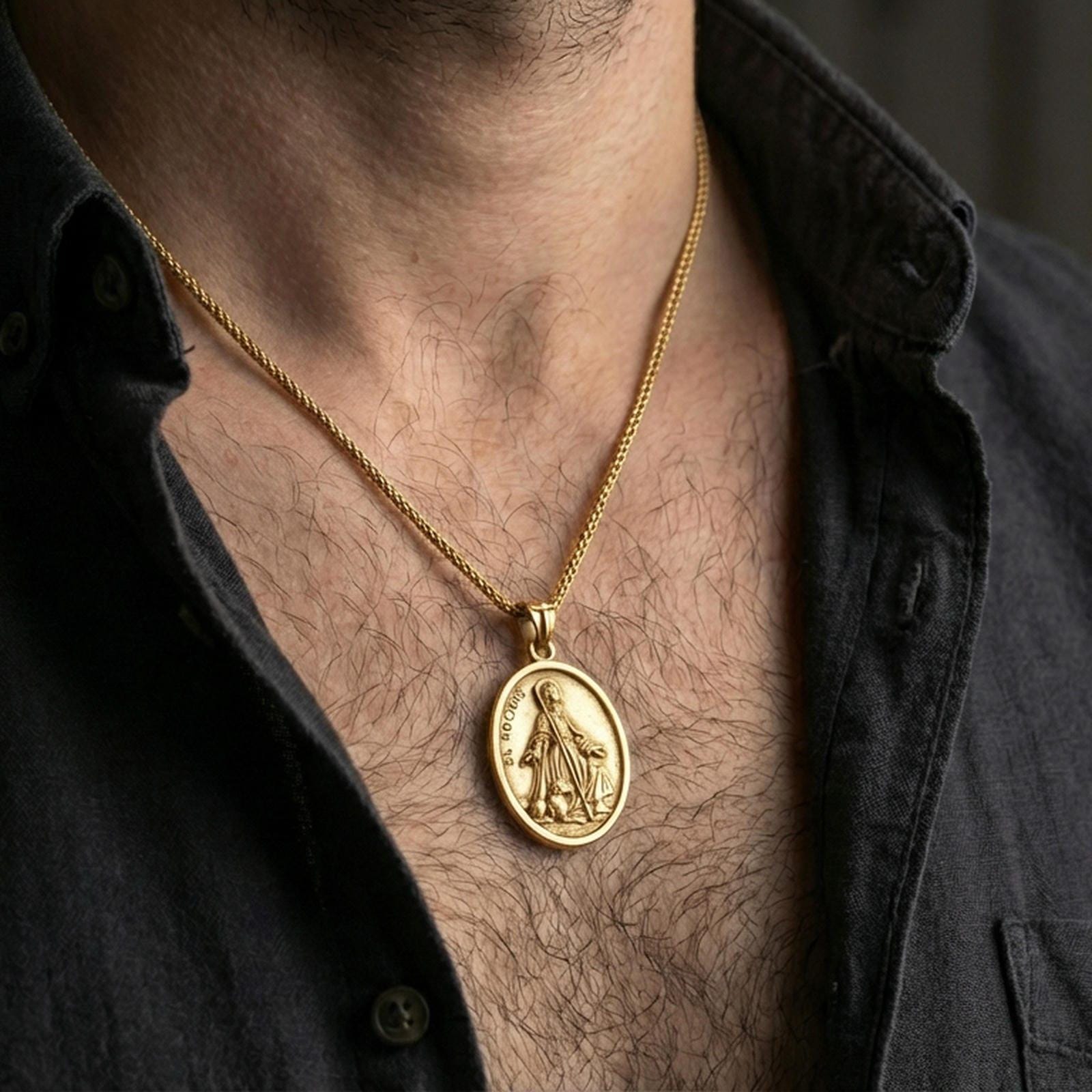 Gold plated Saint Rochus necklace with staff and dog motif worn on the neck in a premium lifestyle composition with classic devotional jewelry styling