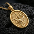 Load image into Gallery viewer, Gold plated Christian resurrection pendant with risen Christ relief, haloed figure, and symbolic banner showcased on black volcanic rock in a refined macro jewelry image

