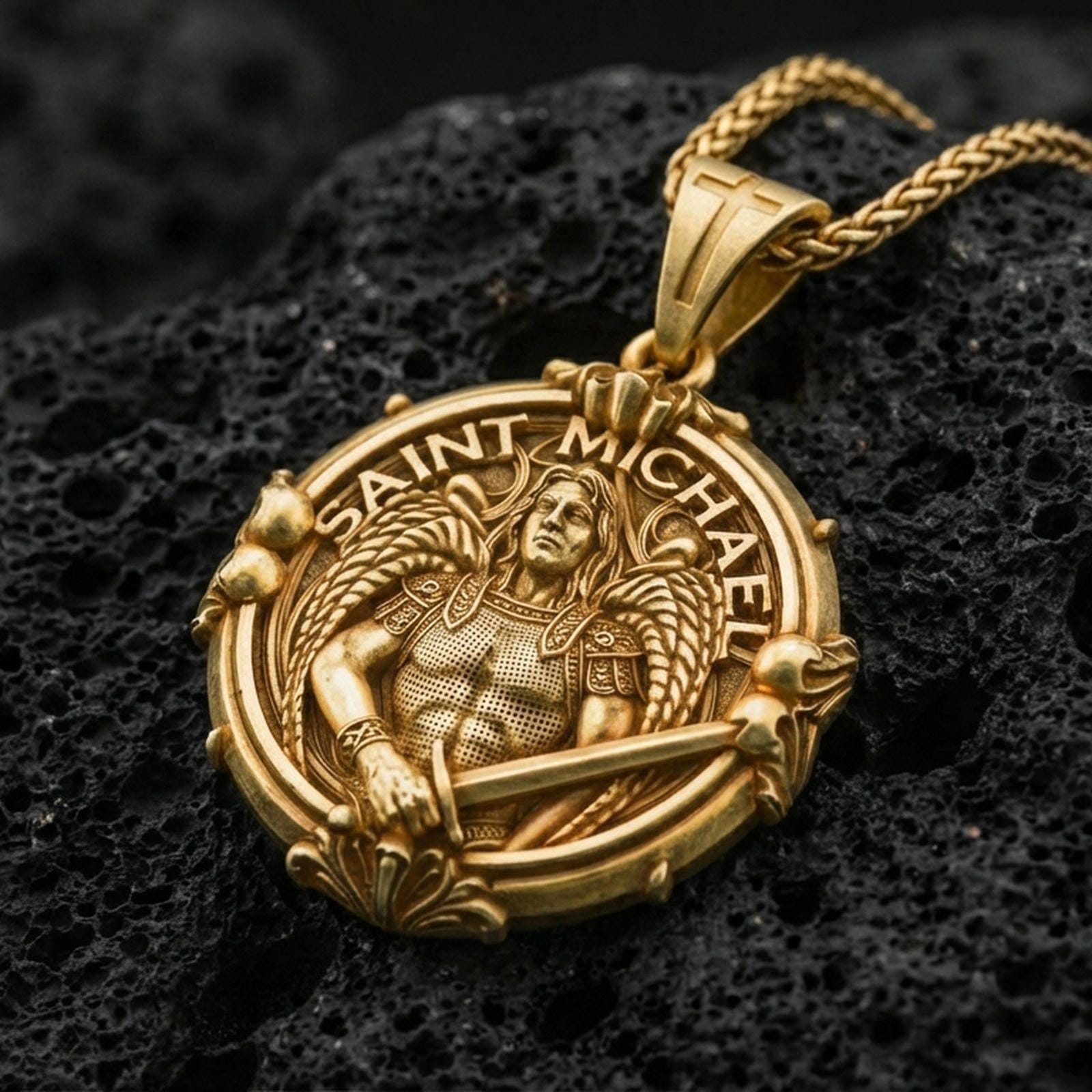 Gold plated Saint Michael necklace with detailed winged guardian, sword motif, and circular devotional design showcased on black volcanic rock in a refined macro jewelry image