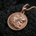 Load image into Gallery viewer, Rose gold plated Heracles lion helmet coin pendant necklace on textured volcanic rock, centered studio-style close-up showcasing soft rosy glow and intricate Greek mythology portrait detailing.
