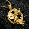 Load image into Gallery viewer, Gold plated Athena warrior pendant necklace on textured volcanic rock, premium close-up with warm reflective shine across the goddess figure, raised Greek meander border, and sculpted drapery texture.
